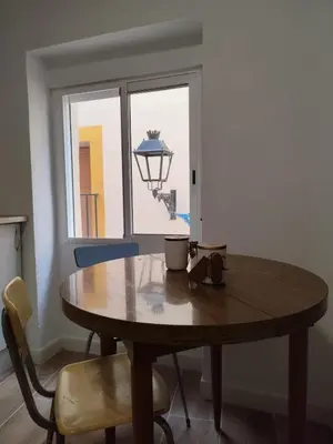 a wooden table and chairs in a room with a window at Casa Centenaria en Cortes de Pallás in Cortez de Pallas