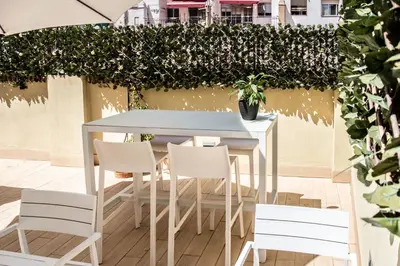 a table and chairs on a patio with a hedge at Zalamera BnB in Valencia
