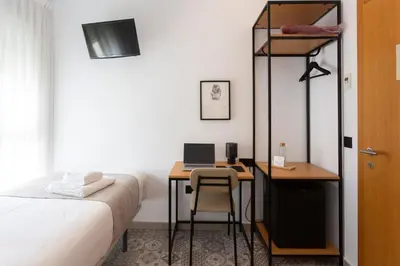 a bedroom with a bed and a desk with a computer at Zalamera BnB in Valencia