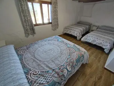 a room with three beds and a table in it at Casa Rebel in Chelva