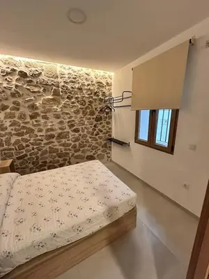 a bedroom with a bed and a stone wall at Apartamento La Fragua - A ESTRENAR - BRAND NEW in Chulilla