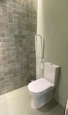 a white toilet in a bathroom with a tile wall at Valencia Malvarrosa Beach point green in Valencia