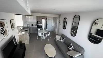 a living room with a couch and a kitchen at Gran Canet, relax y confort a pocos pasos del mar in Canet de Berenguer