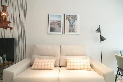 a living room with a white couch with two pillows at District Key - Valencia, O Arocena 1 in Valencia