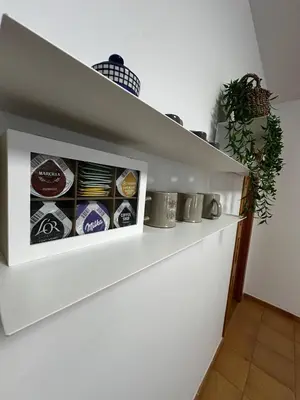 a white wall with a shelf with food items at Casa Durá in Chulilla