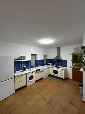 a large kitchen with white appliances and blue tiles at Casa Durá in Chulilla
