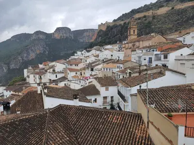 a group of white buildings with mountains in the background at Casa Durá in Chulilla