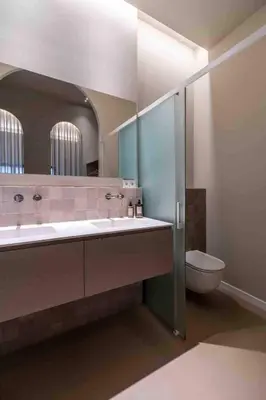 a bathroom with a toilet and a large mirror at Valencia Malvarrosa point beige in Valencia