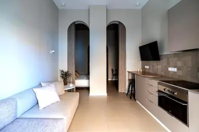 a living room with a couch and a kitchen at Valencia Malvarrosa point beige in Valencia