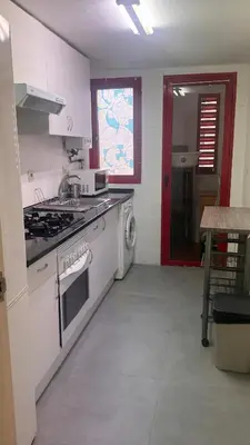 a white kitchen with a stove and a sink at Ciudad de las Artes y Arena Roig apartmento in Valencia