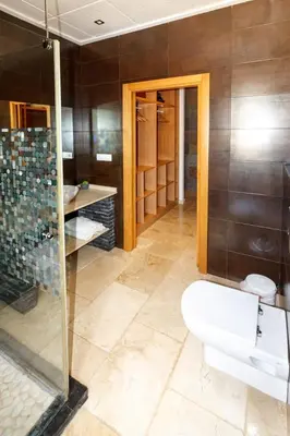 a bathroom with a toilet and a glass shower at La villa de Naomi in Chella