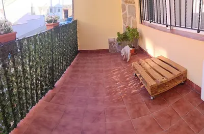 a cat sitting on a balcony with a bench at Cozy townhouse in Soneja in Soneja