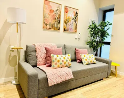 a living room with a gray couch with pink pillows at Cozy & Stylish Loft near City Center in Valencia