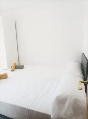 a bedroom with a white bed with a wooden headboard at El Cabañal 400 meters from the Beach in Valencia
