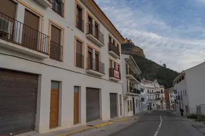 an empty street with buildings and a hill in the background at Miralrio Chulilla in Chulilla