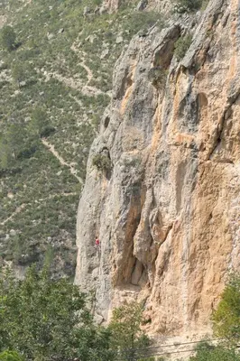 a person rappelling off of a mountain cliff at Miralrio Chulilla in Chulilla