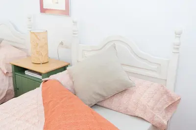 a white bed with a pillow and a table at Miralrio Chulilla in Chulilla