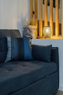 a blue couch with pillows sitting in a living room at Loft bien equipado - Lavavajillas, tostadora, secador, in Valencia