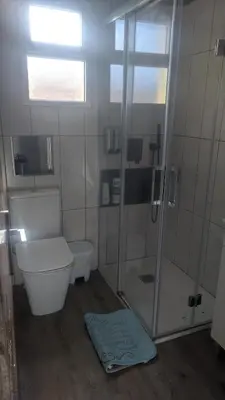 a bathroom with a shower and a toilet and a rug at arena y mar in Tavernes de Valldigna