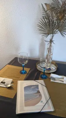 a table with a book and two glasses on it at arena y mar in Tavernes de Valldigna