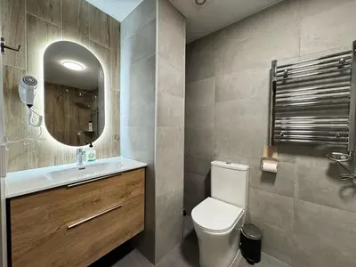 a bathroom with a toilet and a sink and a mirror at Cruilles 13 in Valencia
