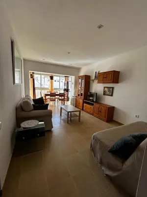 a living room with a couch and a dining room at Amplio apartamento a 250 metros de la playa in Cullera