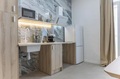 a kitchen with a counter with a sink and a refrigerator at PPA22 Loft Valencia - Acogedor loft cercano al metro Zona Ayora in Valencia