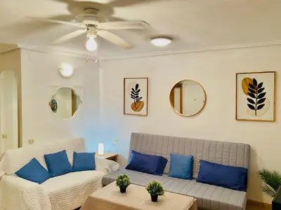 a living room with a couch and blue pillows at Batflats-Palmeres Playa in Sueca