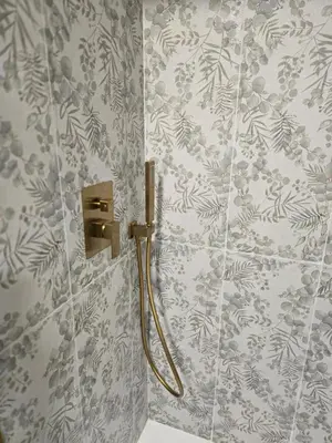 a bathroom with a shower with a hose on the wall at eXperience Apartment Valencia in Valencia