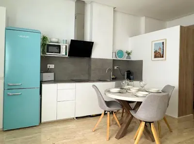 a kitchen with a table and chairs in a kitchen at Apartamento céntrico cerca de Torres de Serrano y Viveros in Valencia