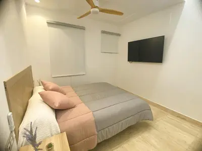 a bedroom with a bed and a flat screen tv at Apartamento céntrico cerca de Torres de Serrano y Viveros in Valencia