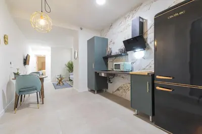 a kitchen with a black refrigerator and a table at AG7 Loft Valencia Espaciosos estudios con terraza cercanos al metro Zona Ayora in Valencia