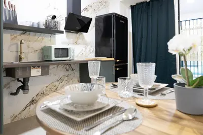 a dining room with a wooden table with plates and glasses at AG7 Loft Valencia Espaciosos estudios con terraza cercanos al metro Zona Ayora in Valencia
