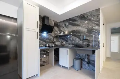 a kitchen with a counter and a stone wall at PALX Loft Valencia - Estudio contemporáneo cerca de las Artes y las Ciencias in Valencia