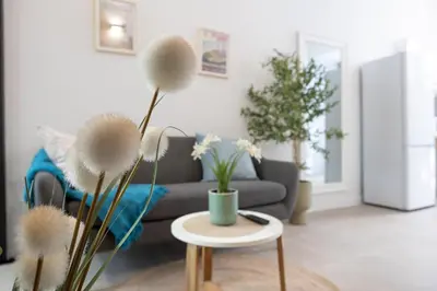 a living room with a couch and a table with flowers at RM1 - Loft Valencia cómodos estudios dúplex cerca a la Avenida del Puerto in Valencia