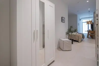 a hallway with white walls and a living room at LO - Loft Valencia - Modernos y acogedores estudios cerca a las Artes y las Ciencias in Valencia