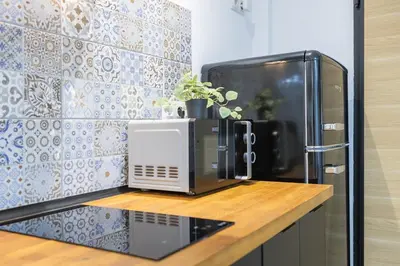 a microwave sitting on a counter next to a refrigerator at LN4 - Loft Valencia Espacioso y acogedor estudio cerca del metro zona Ayora in Valencia
