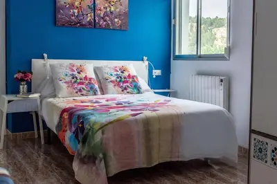 a bedroom with a bed with a colorful blanket on it at La Casa de la Cascada in Anna