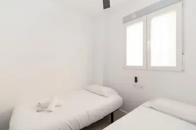 two beds in a white room with a window at GuestReady - A lovely studio in la Saidia Valencia in Valencia