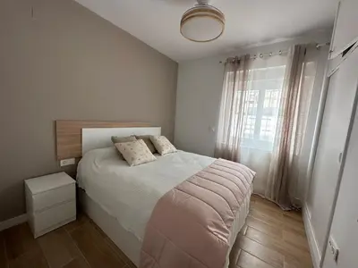 a bedroom with a large bed and a window at La Casita in La Eliana