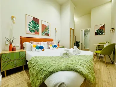 a bedroom with two beds with a green blanket on them at Stylish Design Studio in Valencia in Valencia
