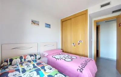 a bedroom with a pink bed and a wooden door at Cozy Apartment In Moncofa in Moncófar
