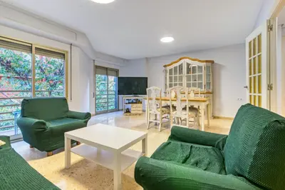a living room with two green couches and a table at Centrally located temporary, very spacious Pataconabluerentals in Valencia