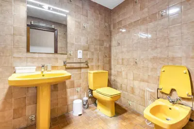 a bathroom with a yellow sink and a toilet at Centrally located temporary, very spacious Pataconabluerentals in Valencia
