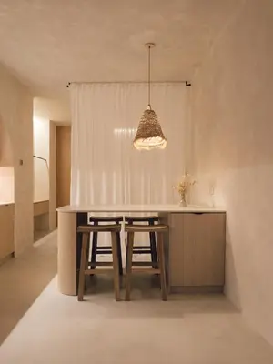 a kitchen with a table with stools and a light fixture at Oasis suites ruzafa in Valencia