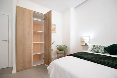 a bedroom with a bed and a wooden closet at RM29 Loft Valencia - Espacioso estudio con terraza en zona Ayora in Valencia