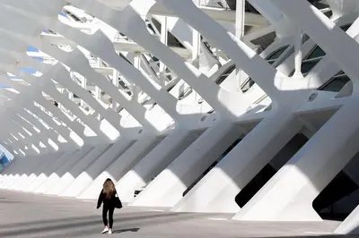 a woman walks in front of a building at RM29 Loft Valencia - Espacioso estudio con terraza en zona Ayora in Valencia