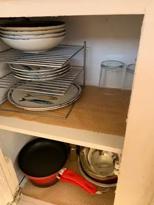 a cabinet with plates and bowls and a red spoon at Barco Varado in Gandía