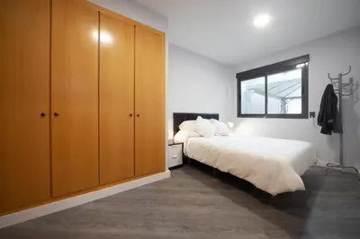a bedroom with a bed and wooden cabinets at Fantástico apartamento con todos los servicios in Canet de Berenguer