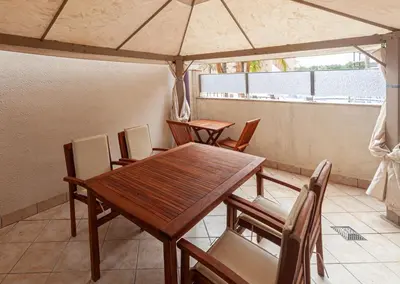 a table and chairs with an umbrella on a balcony at Fantástico apartamento con todos los servicios in Canet de Berenguer